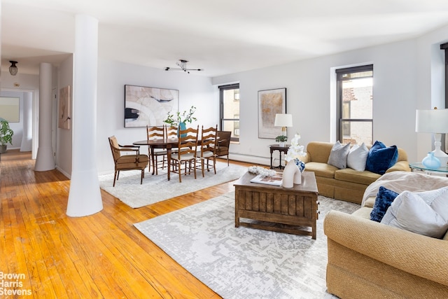 living room featuring light wood-style floors, baseboards, and a baseboard heating unit