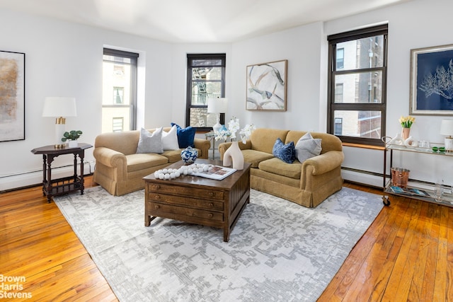 living room featuring a baseboard heating unit and light wood-style flooring