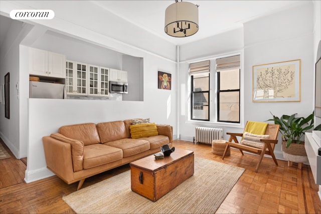 living area with radiator, visible vents, and baseboards