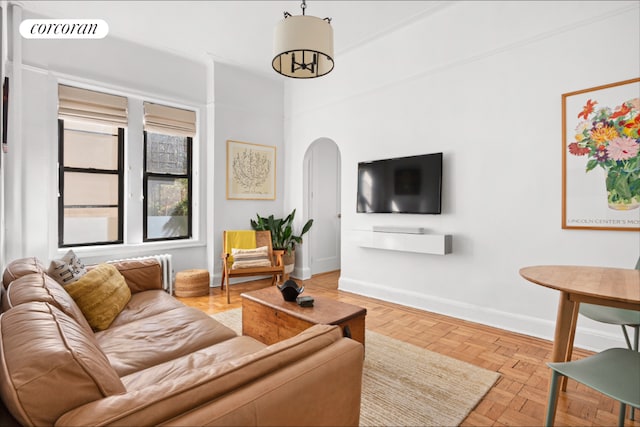 living area with arched walkways, visible vents, and baseboards