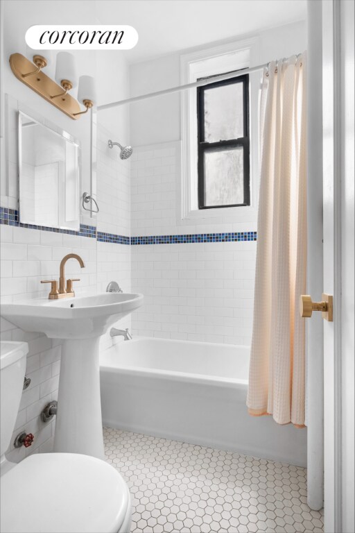 bathroom featuring tile patterned flooring, toilet, tile walls, backsplash, and shower / bath combination with curtain