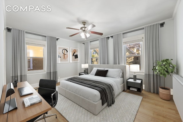 bedroom with radiator, baseboards, ornamental molding, and light wood-type flooring