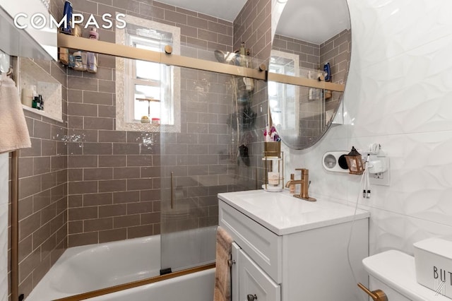 full bathroom featuring tasteful backsplash, toilet, combined bath / shower with glass door, vanity, and tile walls