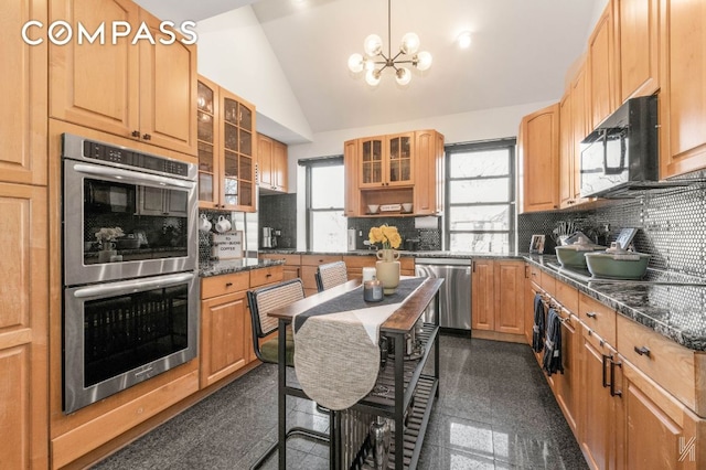 kitchen featuring tasteful backsplash, lofted ceiling, appliances with stainless steel finishes, glass insert cabinets, and granite finish floor