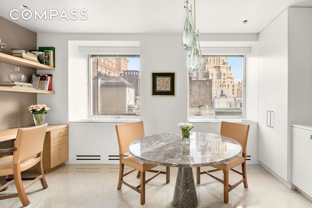 dining room with a wealth of natural light, a city view, and light speckled floor