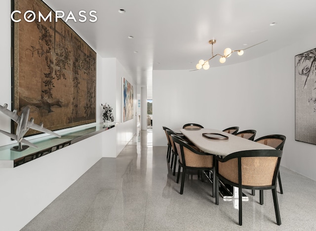 dining space featuring a notable chandelier and light speckled floor