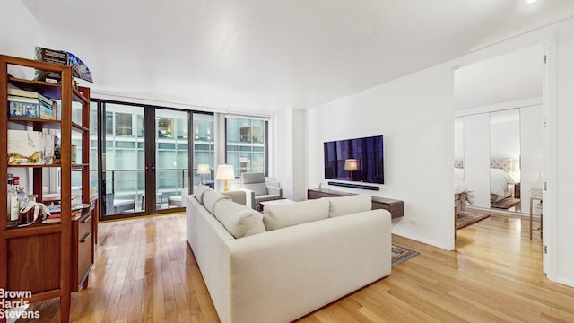 living area with a wall of windows and light wood-style floors