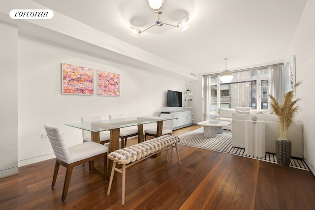 dining room with a chandelier, visible vents, baseboards, and hardwood / wood-style flooring