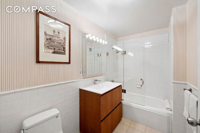 bathroom featuring wainscoting, toilet, and wallpapered walls