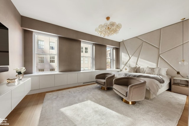 bedroom featuring a notable chandelier and light wood finished floors