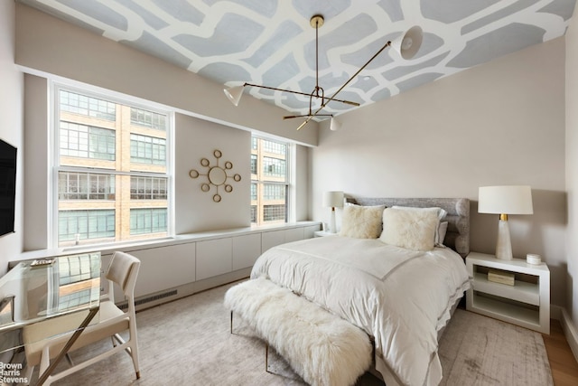 bedroom with a chandelier, light wood finished floors, and visible vents