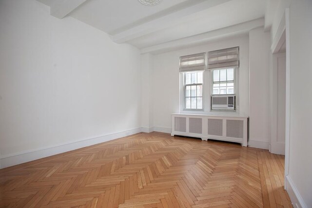 21 E 66th St Unit 4-E, New York City, NY 10065 - empty room featuring baseboards, radiator heating unit, and beam ceiling