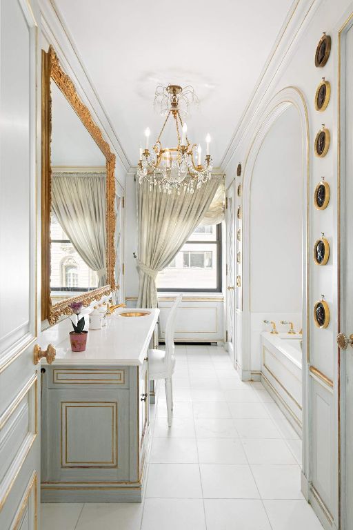 full bath featuring a chandelier, a decorative wall, ornamental molding, a bath, and tile patterned floors