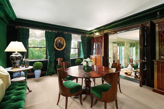 dining space with ornamental molding and light carpet