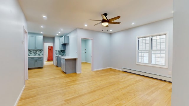 kitchen with light wood-style flooring, a baseboard heating unit, tasteful backsplash, recessed lighting, and light countertops