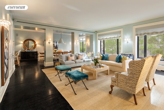 living area featuring baseboards, dark wood-type flooring, visible vents, and crown molding