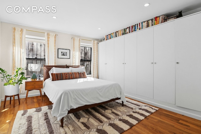 bedroom with recessed lighting and wood finished floors