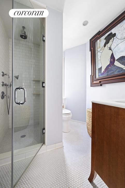 full bathroom featuring toilet, baseboards, tile patterned floors, and a stall shower