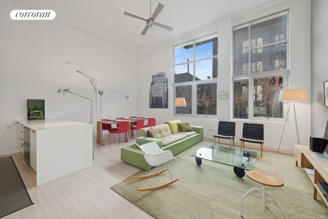 living area featuring visible vents, ceiling fan, and wood finished floors