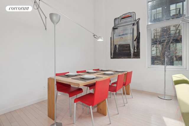 dining area featuring light wood finished floors, visible vents, and baseboards