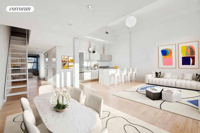 living room with light wood-type flooring, visible vents, stairs, and recessed lighting