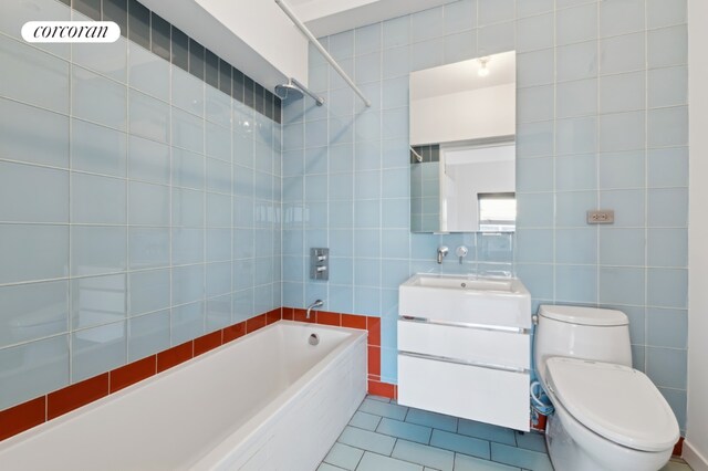 full bath with toilet, tile patterned floors, vanity, shower / washtub combination, and tile walls