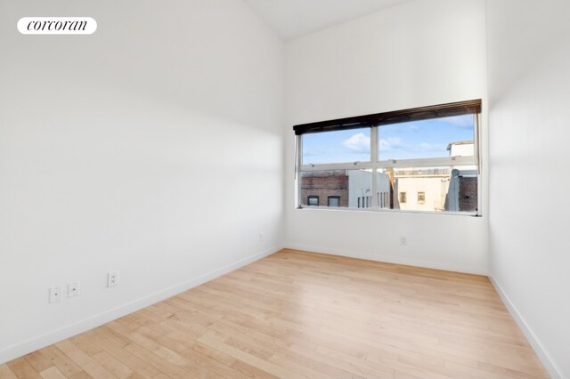 empty room featuring light wood finished floors, visible vents, and baseboards