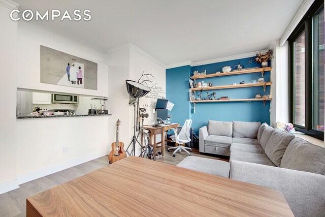 living room with baseboards, ornamental molding, and wood finished floors