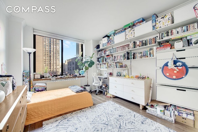 bedroom featuring a view of city and wood finished floors