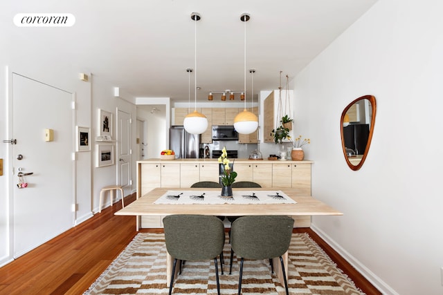 dining room with light wood-style floors, visible vents, and baseboards