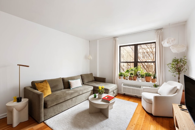 living area featuring a wall unit AC and light wood-style flooring