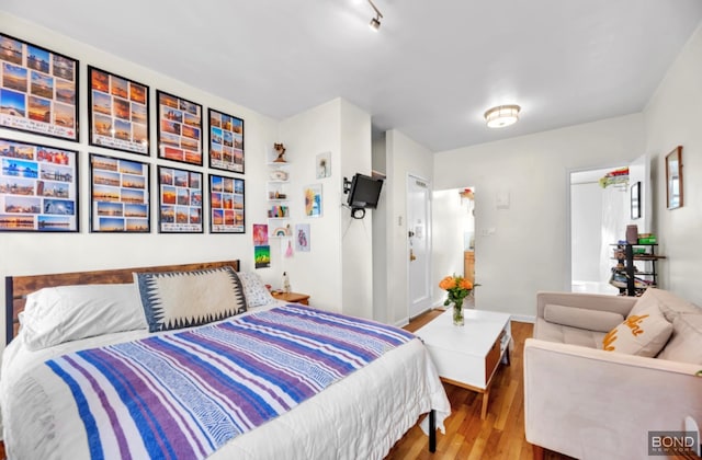 bedroom with baseboards and wood finished floors