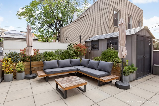 view of patio / terrace featuring a shed, fence, an outdoor hangout area, and an outbuilding