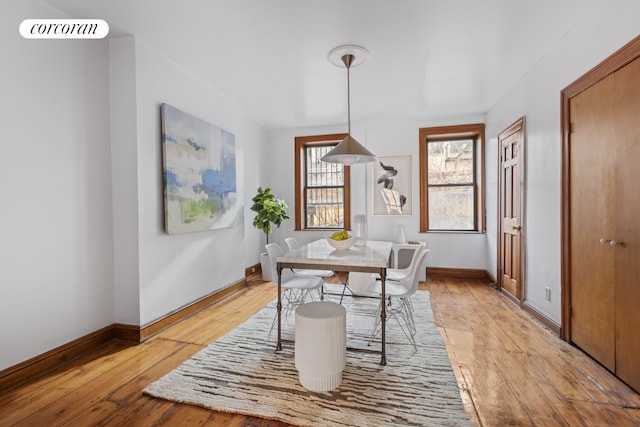 dining room featuring baseboards, visible vents, and light wood-style floors