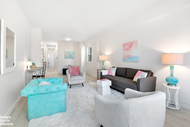 living area featuring light wood-type flooring and baseboards