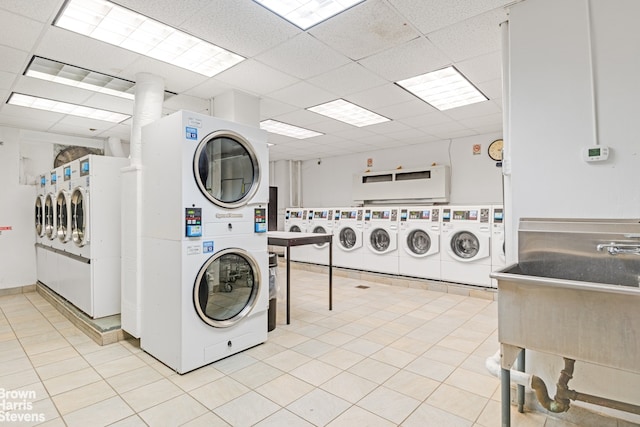 common laundry area with light tile patterned floors, independent washer and dryer, and stacked washer and clothes dryer