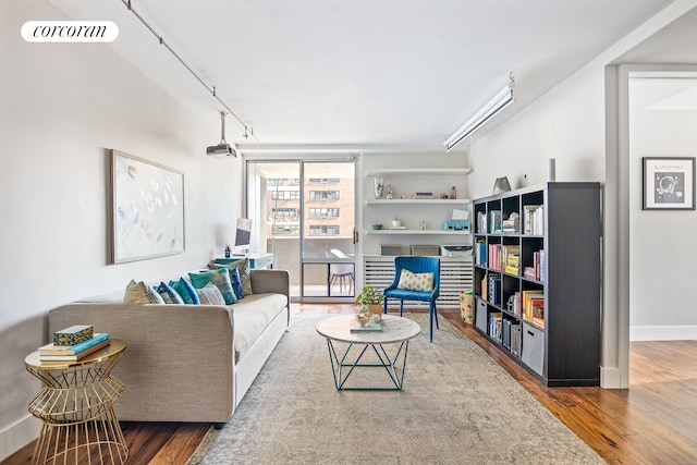 living area featuring baseboards, wood finished floors, visible vents, and track lighting