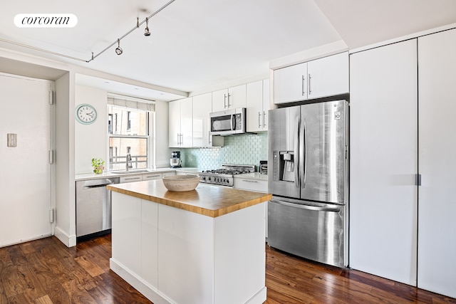 kitchen featuring a center island, dark wood finished floors, stainless steel appliances, visible vents, and backsplash