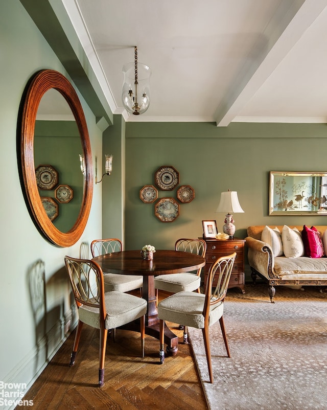 dining space featuring baseboards, beamed ceiling, wood finished floors, and an inviting chandelier