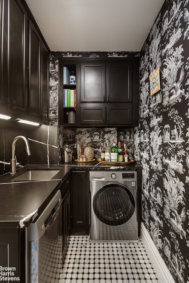 laundry area featuring washer / clothes dryer, wallpapered walls, cabinet space, a sink, and wet bar