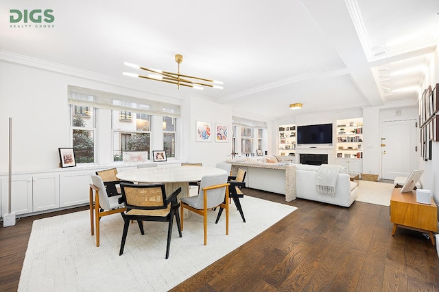 dining area featuring crown molding, dark wood-style flooring, a fireplace, and built in features