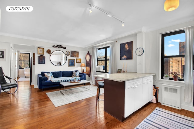 kitchen with white cabinets, visible vents, a peninsula, and wood finished floors