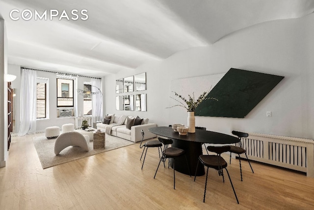 dining space featuring light wood-style floors and radiator