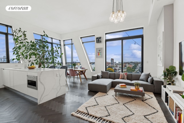 living room with visible vents, a notable chandelier, and baseboards