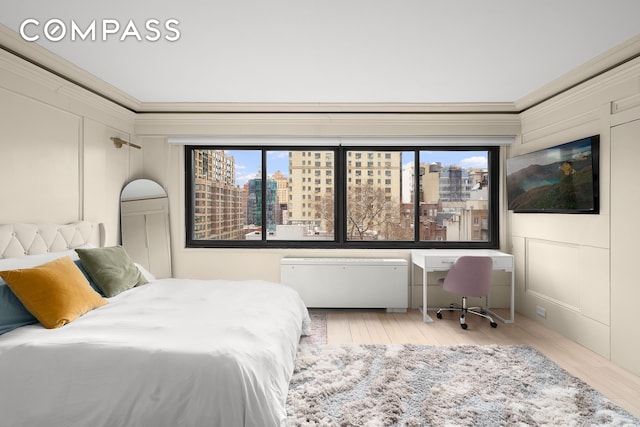 bedroom featuring a decorative wall, multiple windows, and crown molding