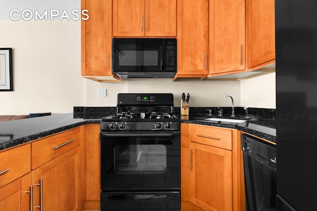 kitchen with black appliances, dark stone counters, brown cabinets, and a sink