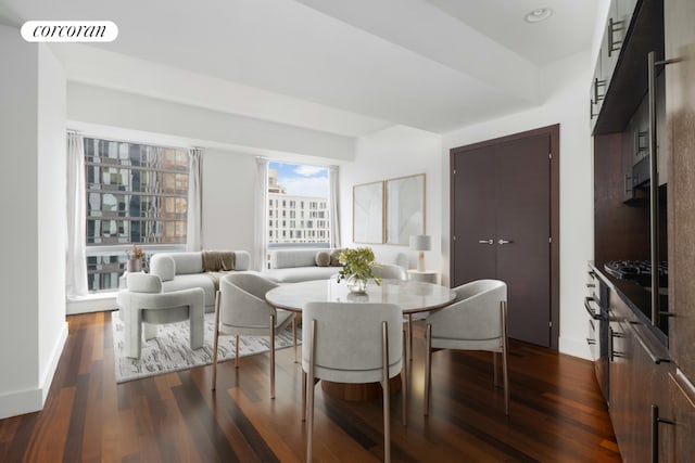 dining space featuring dark wood-style flooring, visible vents, and baseboards