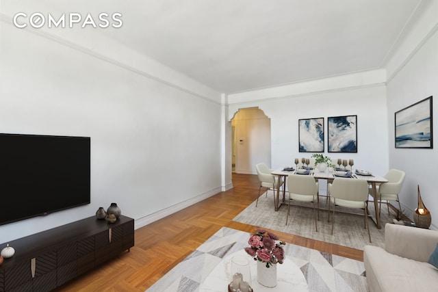 living room featuring baseboards and arched walkways