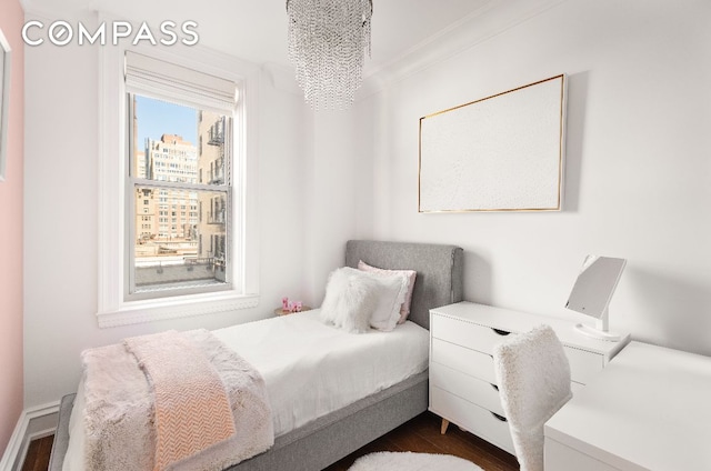 bedroom with a view of city and dark wood finished floors