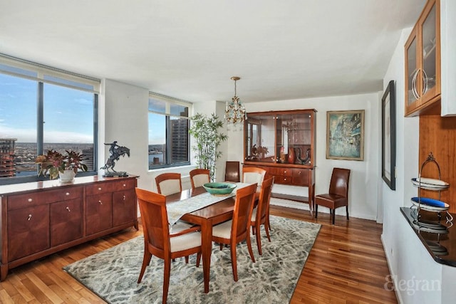 dining space featuring wood finished floors and a notable chandelier